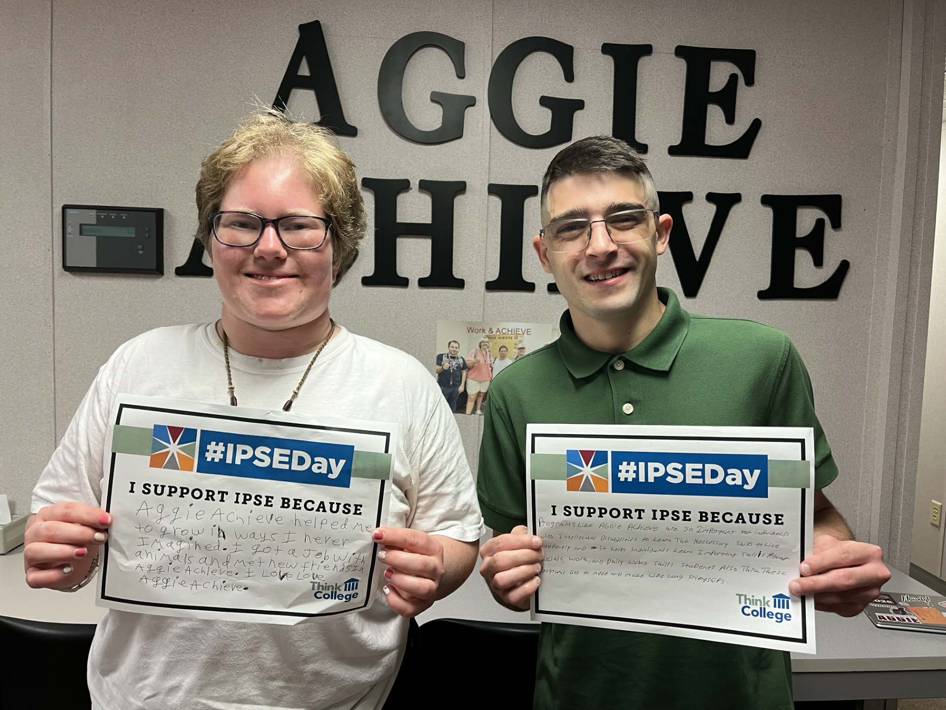 Two students from the Aggie ACHIEVE Program holding IPSED Day support papers.