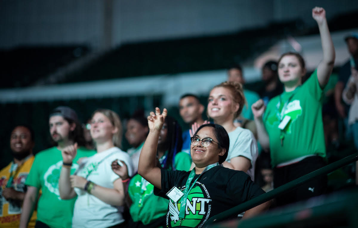 Students from UNT Elevar Program at a game. Cheering in the bleachers.