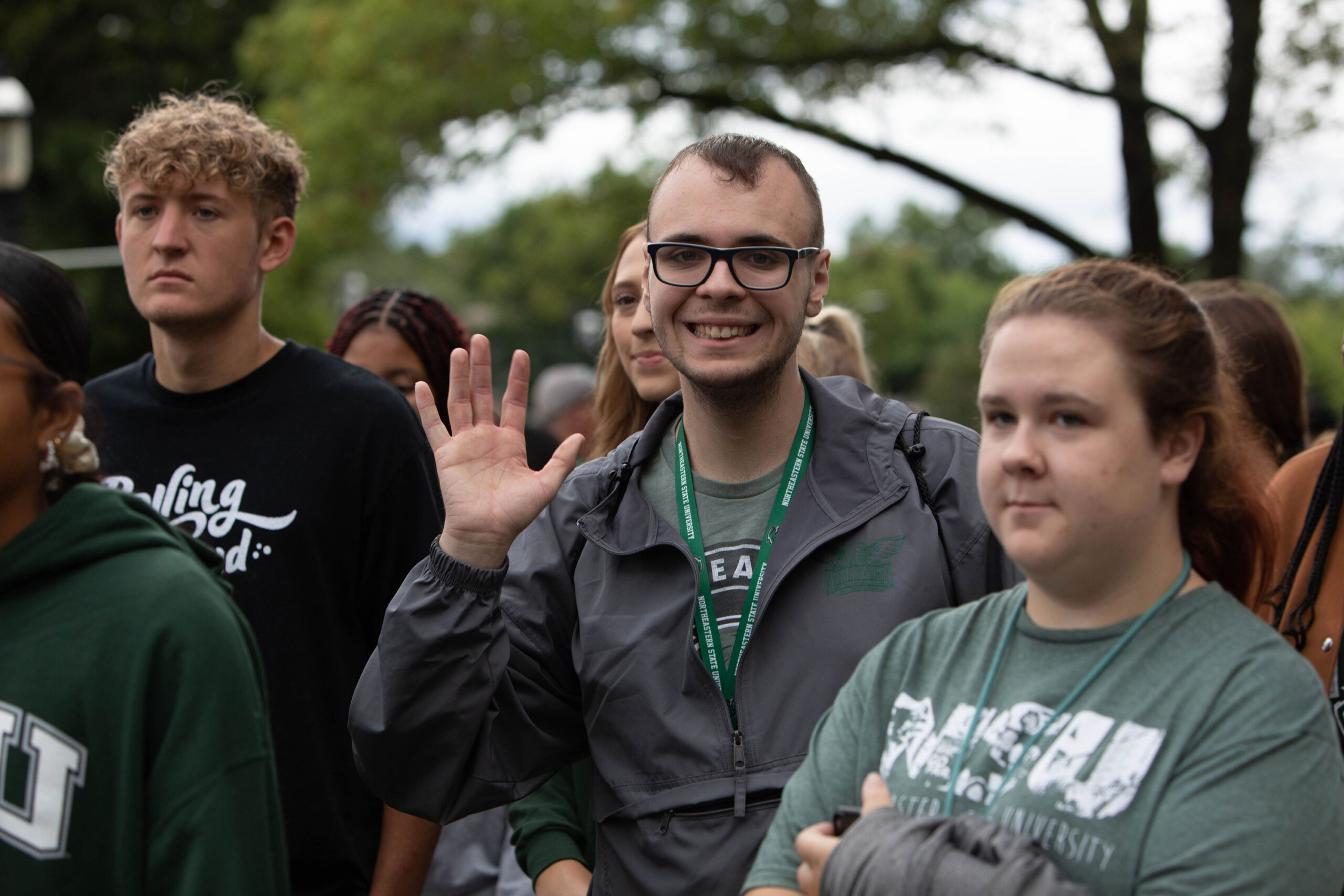 Students from Northeastern State University's RiverHawks Scholarship Program. One student is waving.