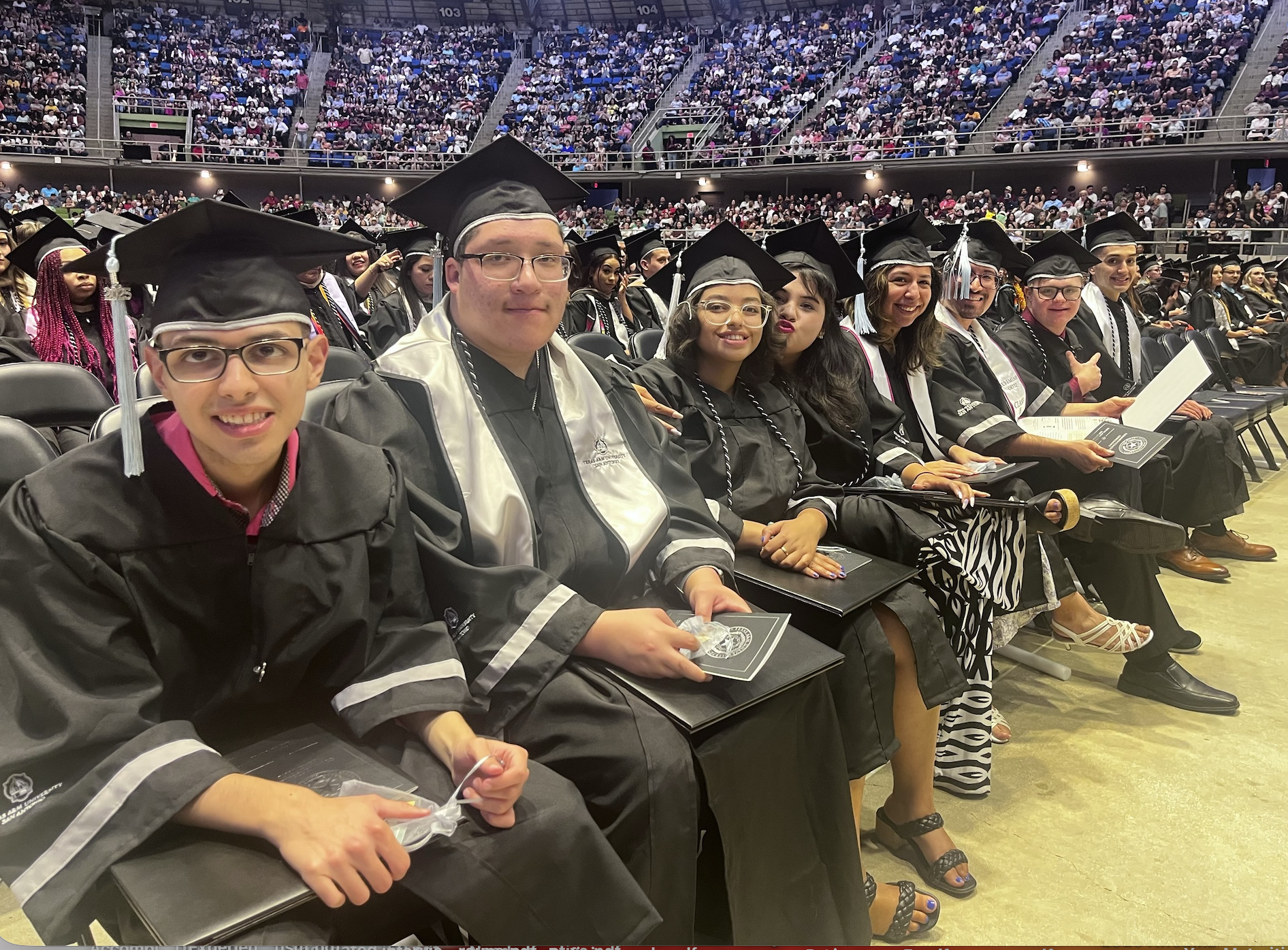 Graduating student from the TU CASA Program. Student is wearing a graduation gown and holding his cap.